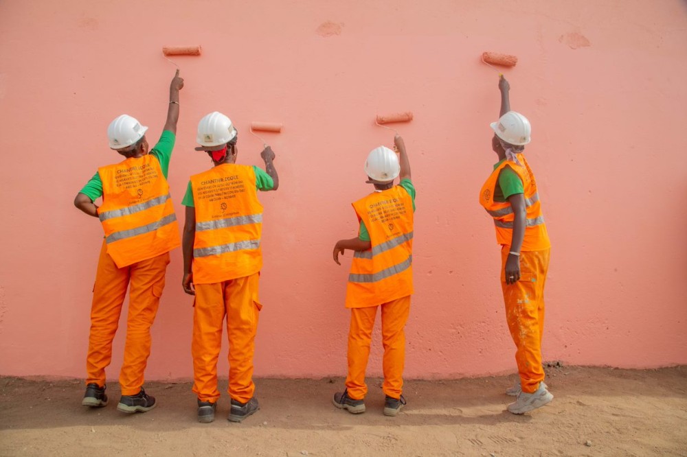 Returnees in the midst of plastering a building being rebuilt Bouaké, Côte d’Ivoire. © IOM 2021/Mohamed Aly DIABATÉ