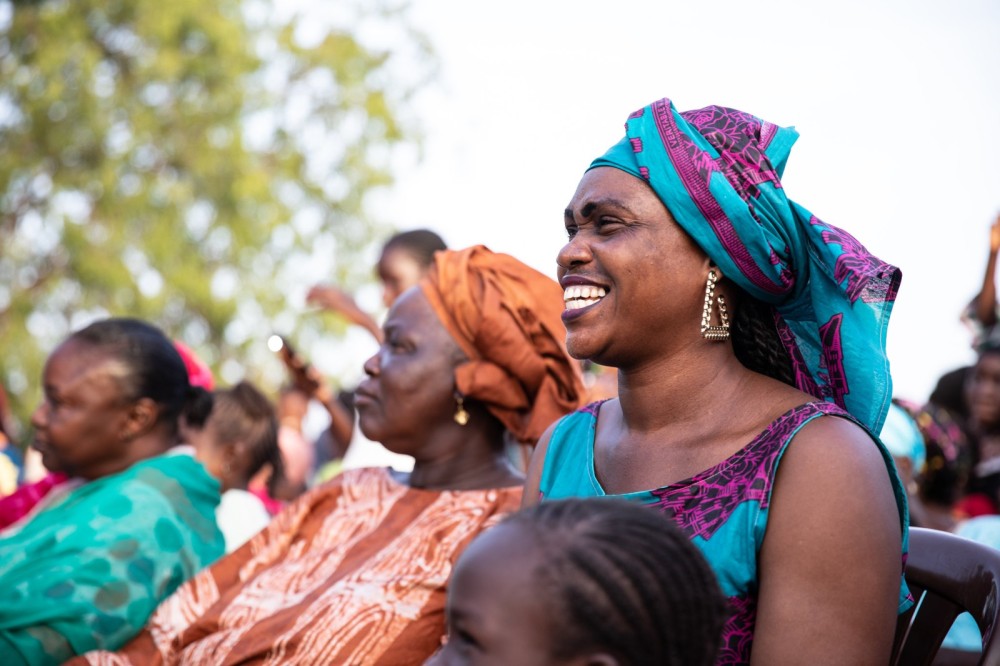 Social theater is one of the participative approaches featured on Yenna. In this picture, Senegalese women enjoy a local outdoors performance organised by IOM Author: Migrants as Messenger / Copyright: IOM