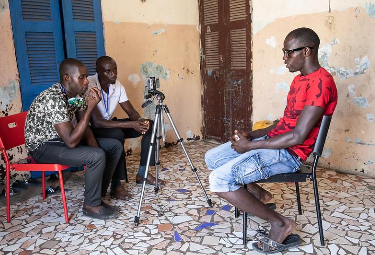 Migrants as Messengers volunteers interviewing a returnee migrant in Kayar, Senegal, image by IOM